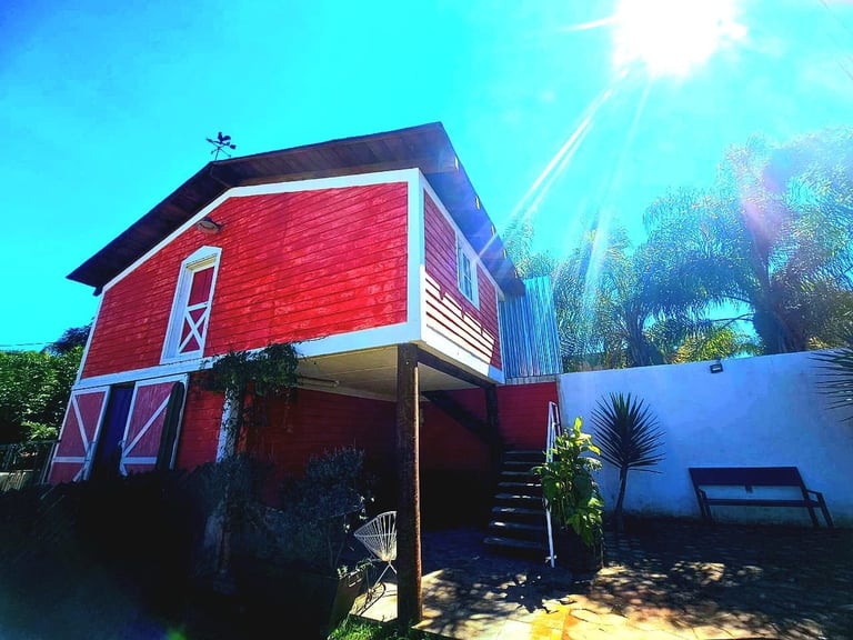 Casa moderna roja con arquitectura angular rodeada de palmeras